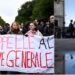 A protester shouts slogans in a megaphone as others hold a banner during a demonstration over learning conditions in Paris on October 22, 2026, as France braced for more demonstrations just days after student and other rallies degenerated into some of the worst street unrest in years. The administrative court has issued an emergency order suspending the decree issued by the Paris Police Prefecture banning a demonstration organised for October 22, 2026 by Interfac Ile-de-France an organisation comprising students from university general assemblies between La Pitie-Salpetriere and Bastille, starting at 2.00 pm. (Photo by JULIEN DE ROSA / AFP)